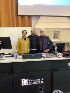 Photo of Tzuchien Tho, Karim Thebault and Richard Arthur standing at the front of a lecture theatre.